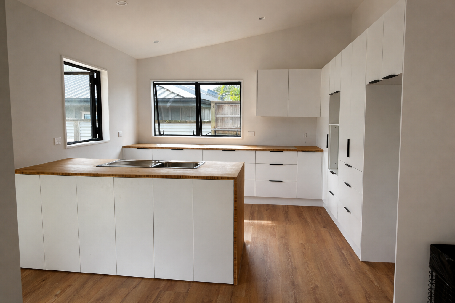 Modern kitchen with white cabinets and wooden countertops